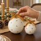 Mellow Monkey star-studded ornament candles in white with gold stars and velvet bows on a festive dining table.