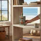 Mellow Monkey embossed stoneware bottle with cork stopper, featuring two brown fish designs. 7-3/4-inch coastal decor.