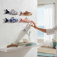 Mellow Monkey hand-painted stoneware fish wall decor in blue floral, white floral, pink stripe, and wood grain patterns.