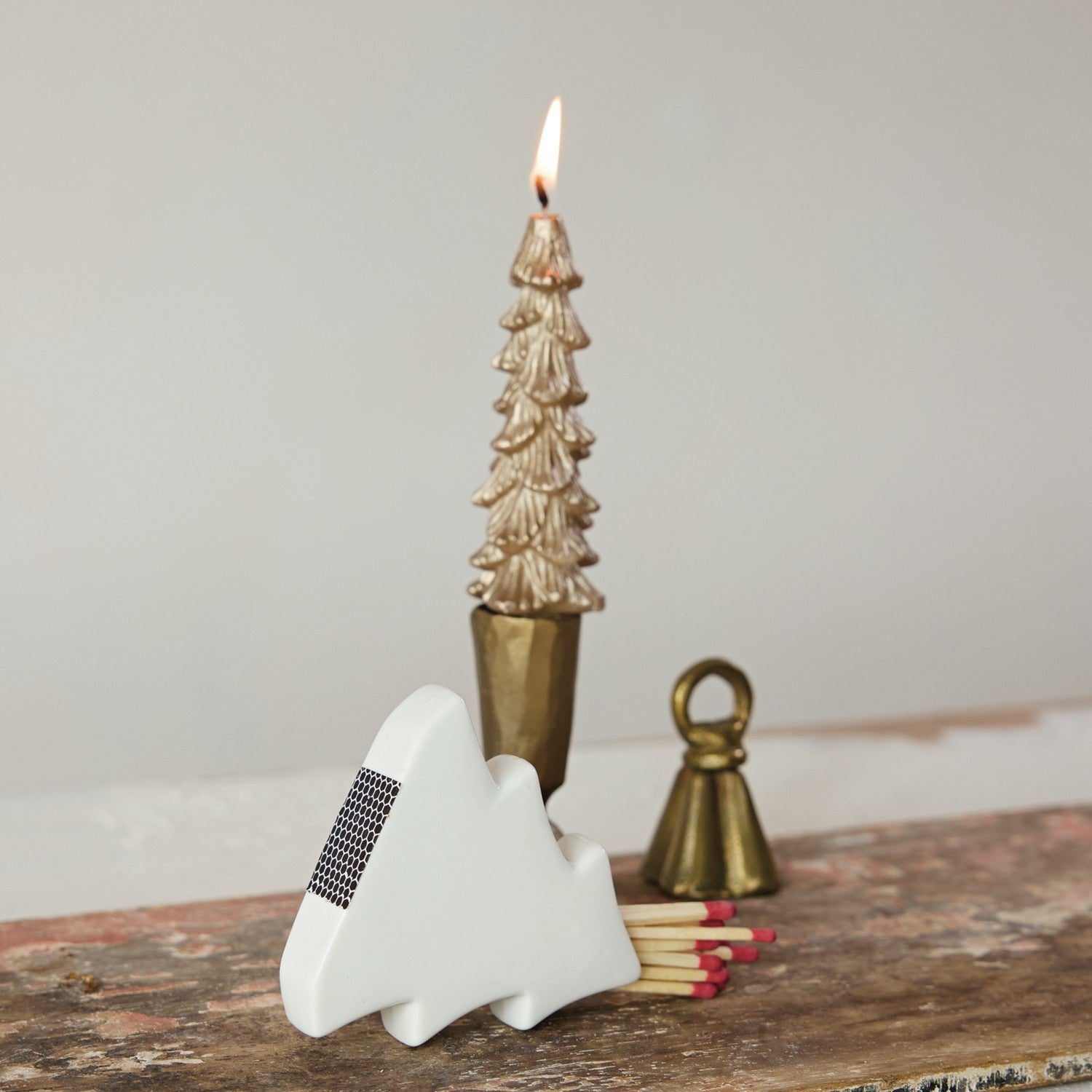 Mellow Monkey white stoneware tree-shaped match holder with integrated striker on a rustic wooden mantel