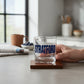Mellow Monkey Stratford rocks glass with blue lettering on a wooden coaster in a bright kitchen setting.
