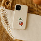 Mellow Monkey strawberry Kewpie sticker on a beige phone case resting on a textured cream cloth and rattan surface.