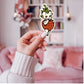 Mellow Monkey vintage-inspired Strawberry Kewpie vinyl sticker held in a hand against a blurred pink living room