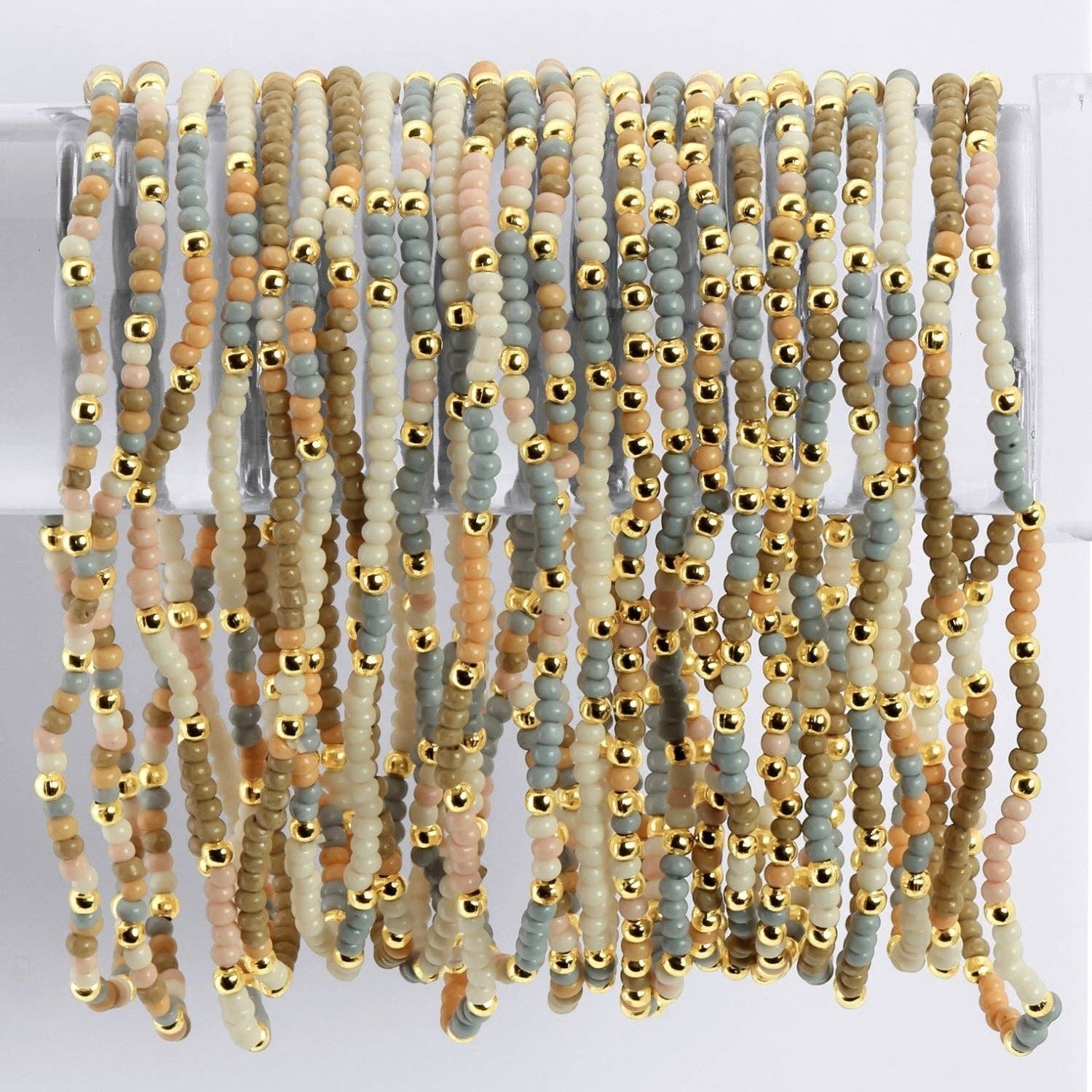 Mellow Monkey stretch seed bead bracelets in taupe, peach, and grey with 18k gold-plated brass accents.