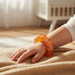 Mellow Monkey Sunburst Orange Feelzies sensory bracelet with glitter on a child's wrist for stress relief
