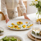 Mellow Monkey 18-inch ceramic oval platter featuring a vibrant sunflower pattern on a white textured background.