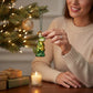 Mellow Monkey Mini T-Rex blown glass holiday ornament, green with gold accents, hanging on a Christmas tree.