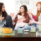 Mellow Monkey TABLETOPICS TEEN conversation cards in an acrylic cube on a coffee table with three teenage girls