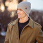 Mellow Monkey Britt's Knits Tahoe beanie in grey moss stitch with rib knit cuff worn by a man in a winter coat