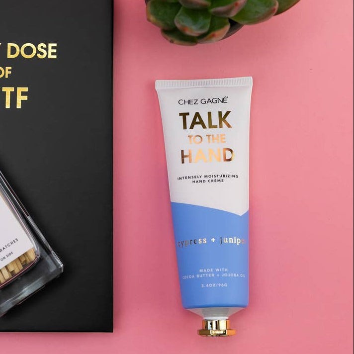 Mellow Monkey Talk to the Hand cypress and juniper scented hand cream in a white and blue tube with a gold cap.