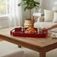 Mellow Monkey 16-inch red iron serving tray featuring a festive tartan plaid pattern on a rustic wooden coffee table.