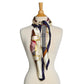 Mellow Monkey silky scarf featuring a cream, navy, and red tartan pattern with gold equestrian buckle motifs.