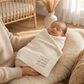 Mellow Monkey taupe soft knit cotton baby blanket with You Are Loved Beyond Measure text, swaddling a newborn baby.