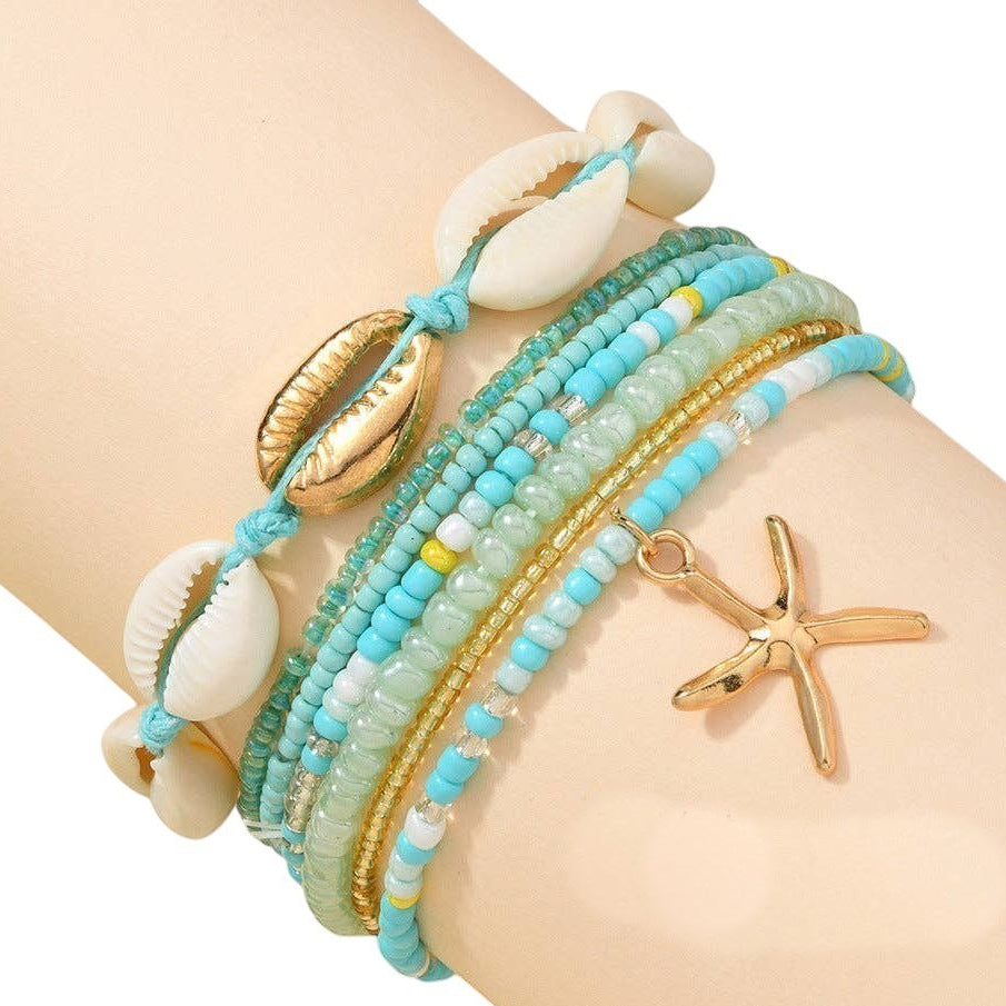 Mellow Monkey teal beaded bracelet set with seashell and gold starfish charms for a bohemian beach style look.