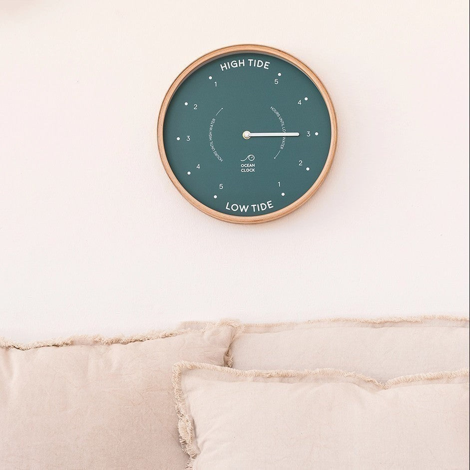 Mellow Monkey 12-inch round teal tide clock with a natural beech wood frame and white hands, displaying hours until high and low tide.