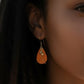 Mellow Monkey teardrop earrings with wisp and bead detail worn by a woman on a beach at sunset