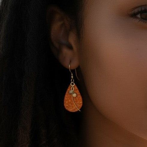 Mellow Monkey teardrop earrings with wisp and bead detail worn by a woman on a beach at sunset