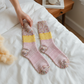 Mellow Monkey Whimsical Multi textured crew socks in soft pink with yellow and multi-colored speckled patterns.