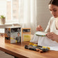 Mellow Monkey The Office mini cross-stitch kit with embroidery hoop, thread, and guide on a wooden table