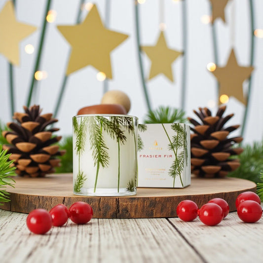 Mellow Monkey Thymes Frasier Fir poured candle in a glass vessel with pine needle print on a wooden board