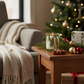 Mellow Monkey Thymes Frasier Fir votive candle in a glass jar with pine needle design on a festive holiday side table