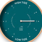 Mellow Monkey 12-inch Peacock Wood Sailor Tide Clock with white hands and a teal face indicating hours until high or low tide.