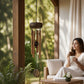 Mellow Monkey Tiger's Eye mini wind chime with wooden canopy and aluminum tubes hanging on a serene garden patio.