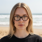 Mellow Monkey round tortoiseshell magnetic reading glasses worn by a woman on a sunny beach.