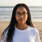 A woman wearing Mellow Monkey tortoiseshell pocket reading glasses on a beach at sunset.