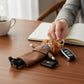 Mellow Monkey fashion doll keychain with trench coat, scarf, boots, and handbag. Camel color.
