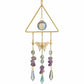 Mellow Monkey triangle suncatcher with crystals, amethyst stones, butterfly charm, and gold chains hanging in a window.