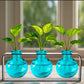 Mellow Monkey Trivo triple aqua recycled glass ball vases in a sleek black metal stand with green plant cuttings.