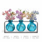 Mellow Monkey Trivo triple aqua recycled glass vases in a sleek black metal stand holding pastel sweet pea flowers.