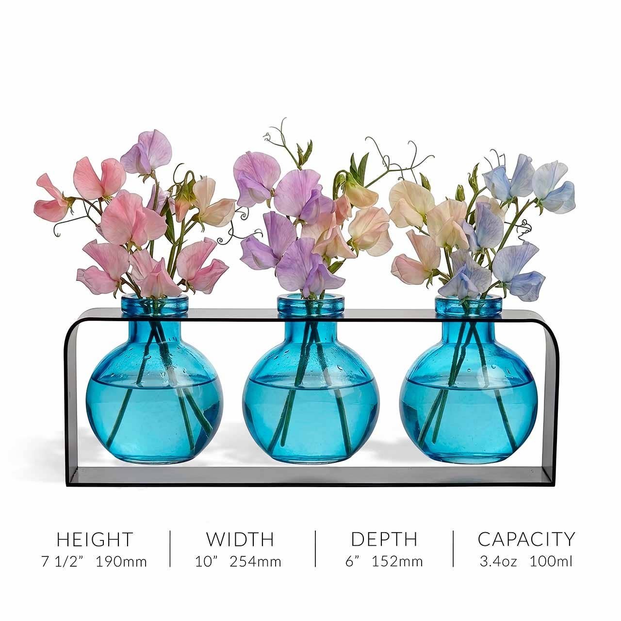 Mellow Monkey Trivo triple aqua recycled glass vases in a sleek black metal stand holding pastel sweet pea flowers.