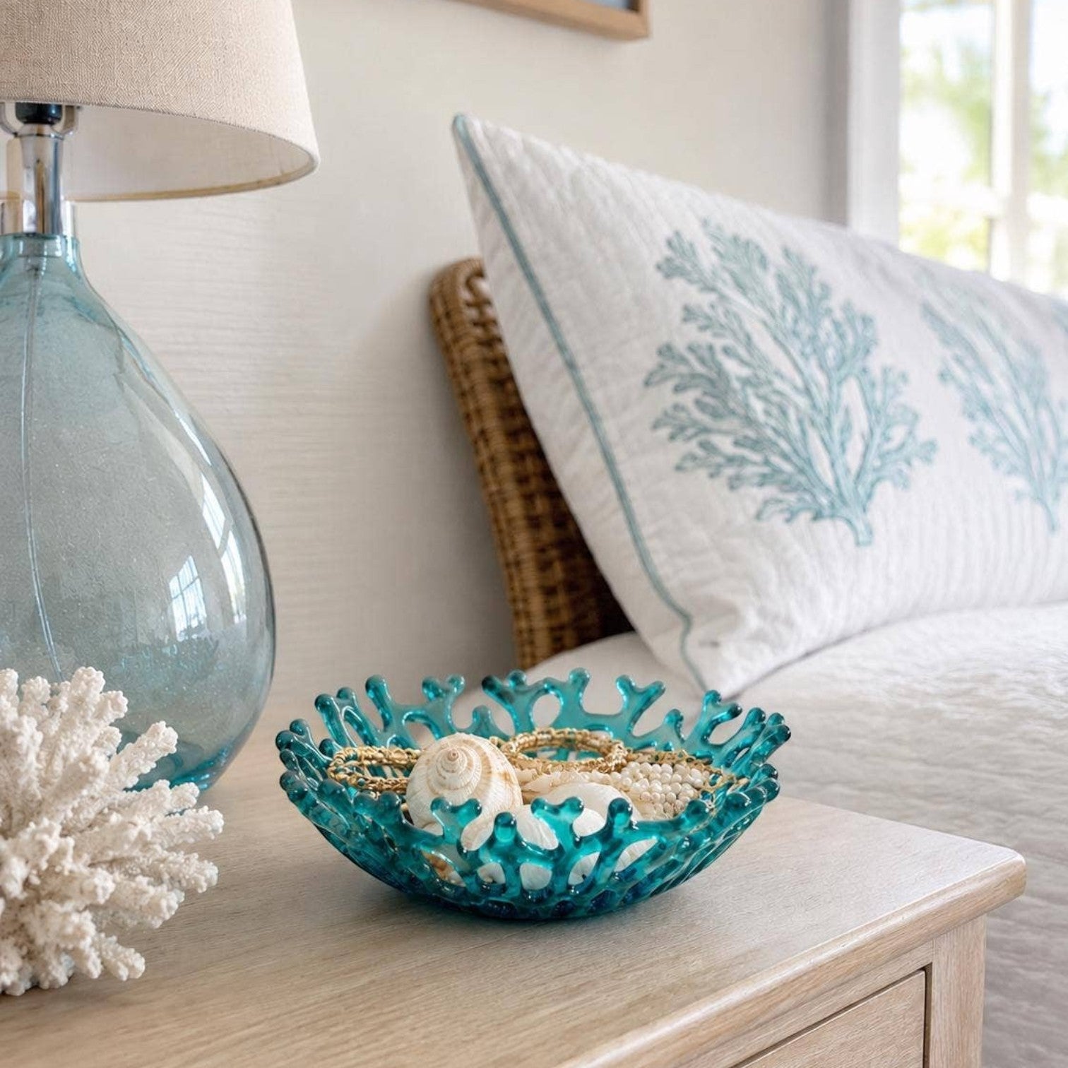 Mellow Monkey handmade turquoise fused glass coral bowl holding seashells on a wooden nightstand