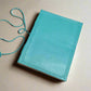 Mellow Monkey turquoise leather journal with debossed corners and elastic closure, unlined pages, 8x6 inches.