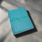 Mellow Monkey turquoise leather journal with debossed corners and elastic closure, 8x6 inches, unlined pages.