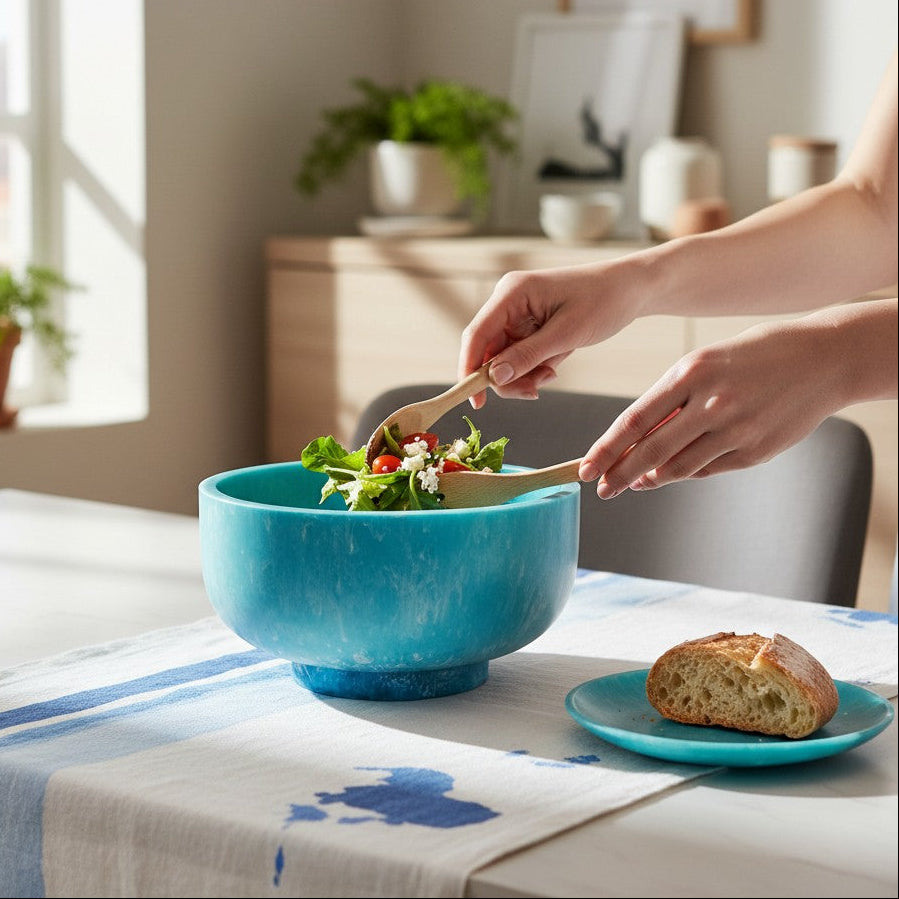 Mellow Monkey large turquoise and blue resin bowl with base being used to serve a fresh salad on a dining table.