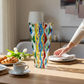 Mellow Monkey 12-inch hand-painted Venetian glass vase with colorful wavy patterns on a dining table.