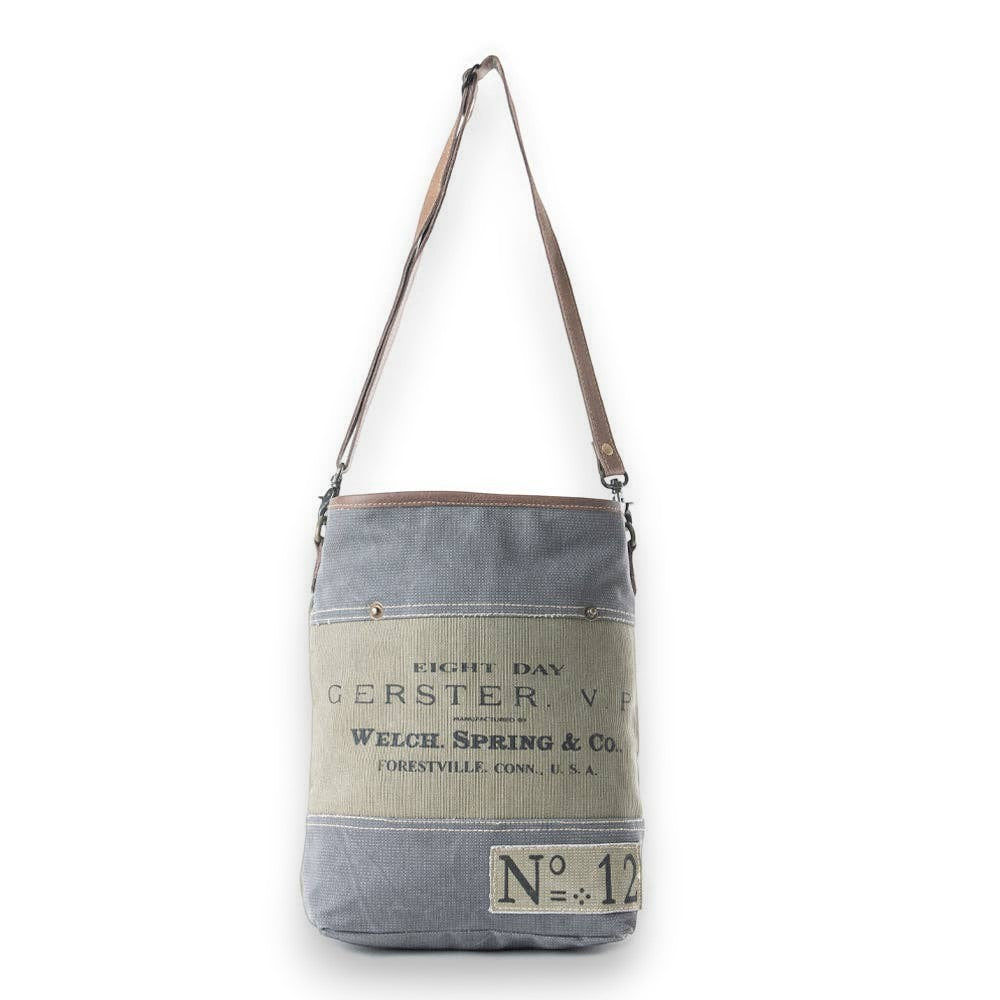 Mellow Monkey Vespertine shoulder bag in vintage grey canvas and brown leather with printed typography.