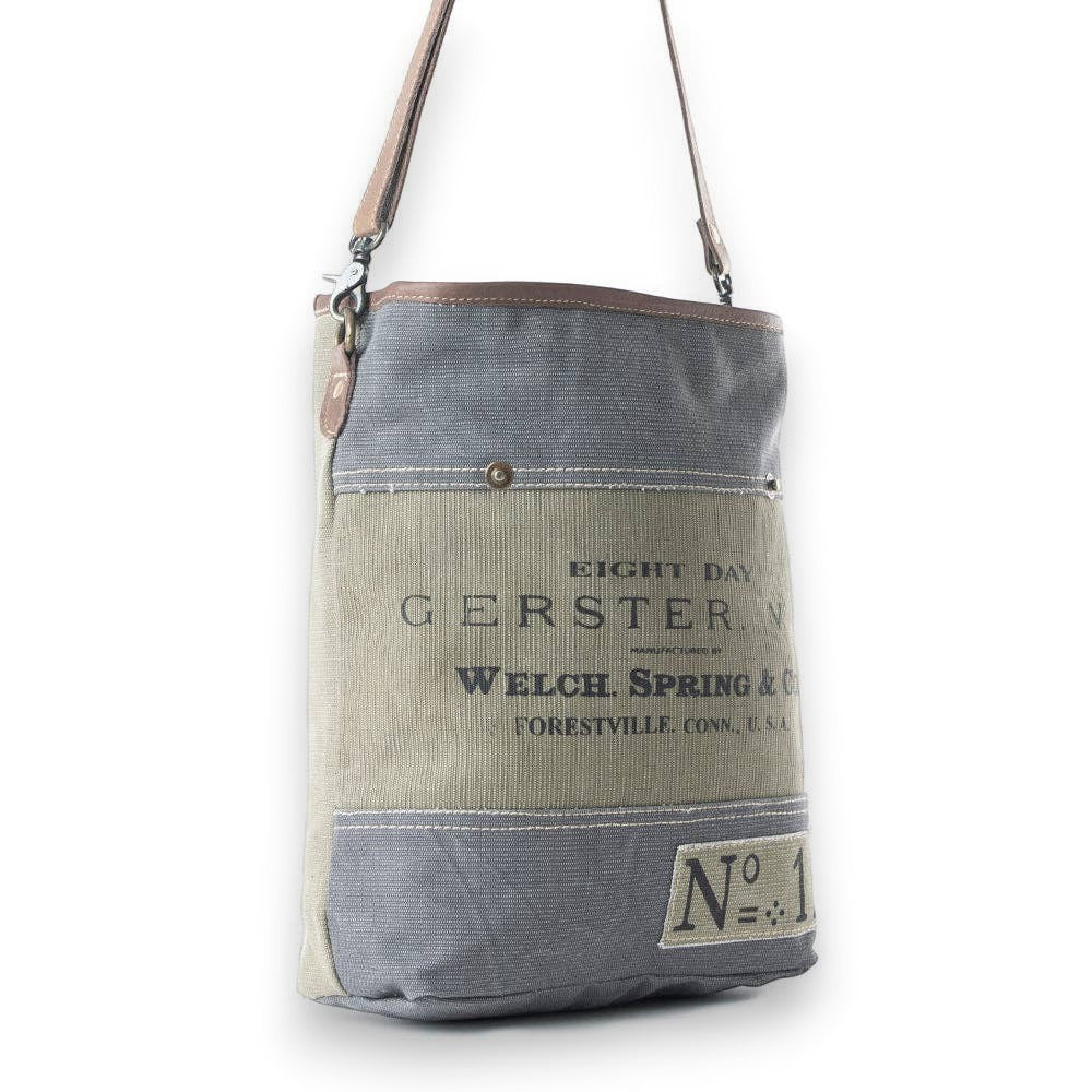 Mellow Monkey Vespertine shoulder bag in grey and olive canvas with brown leather trim and vintage typography print.