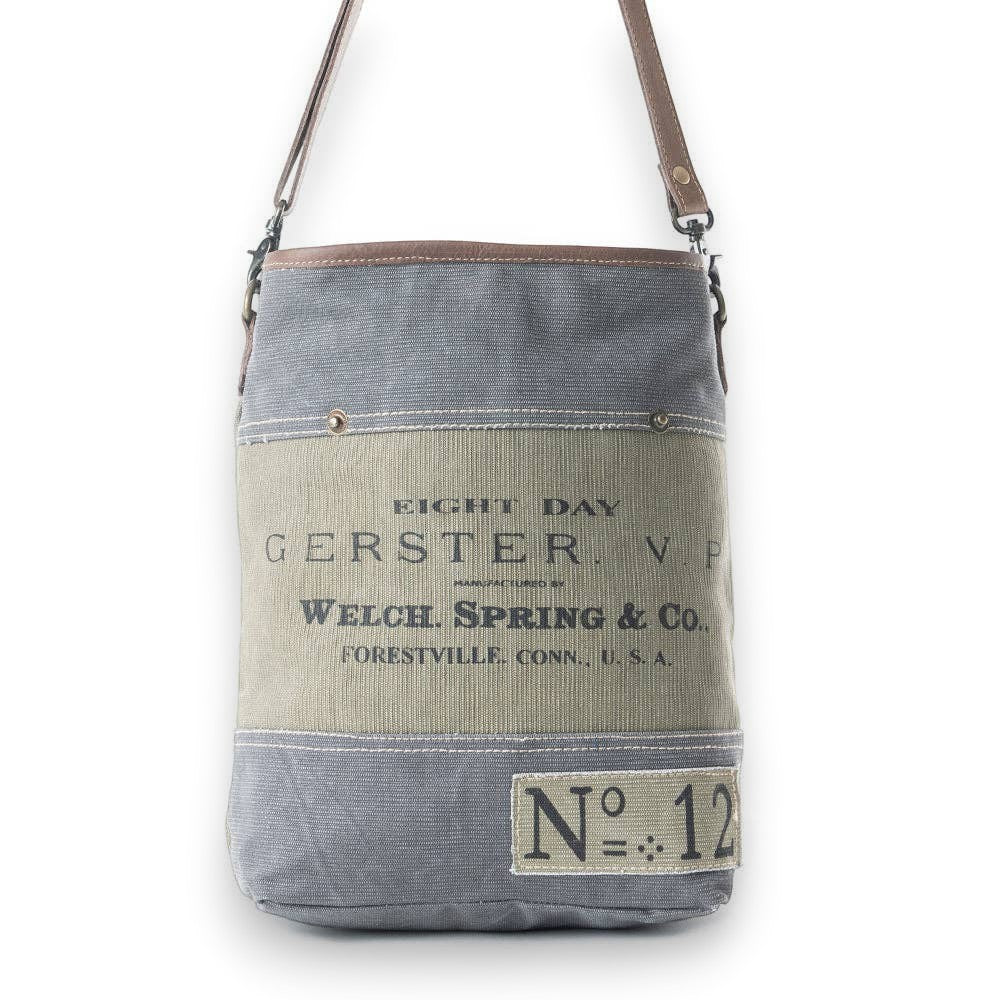 Mellow Monkey Vespertine shoulder bag in grey canvas and brown leather with vintage typography and metal hardware.