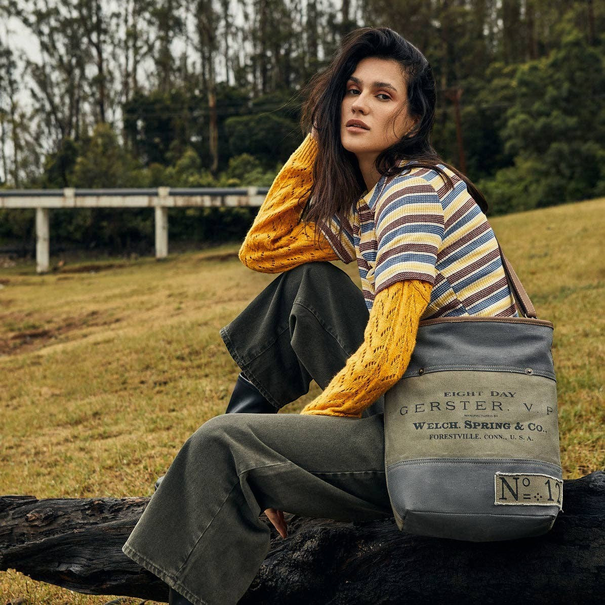 Mellow Monkey Vespertine shoulder bag in vintage canvas and leather, featuring printed typography, worn outdoors.