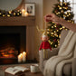 Mellow Monkey vintage-style fabric elf ornament with gold hat, red outfit, and posable limbs held in a cozy room.