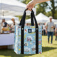 Mellow Monkey Virginia Bagette market tote with blue illustrated print and black reinforced handles held at a market