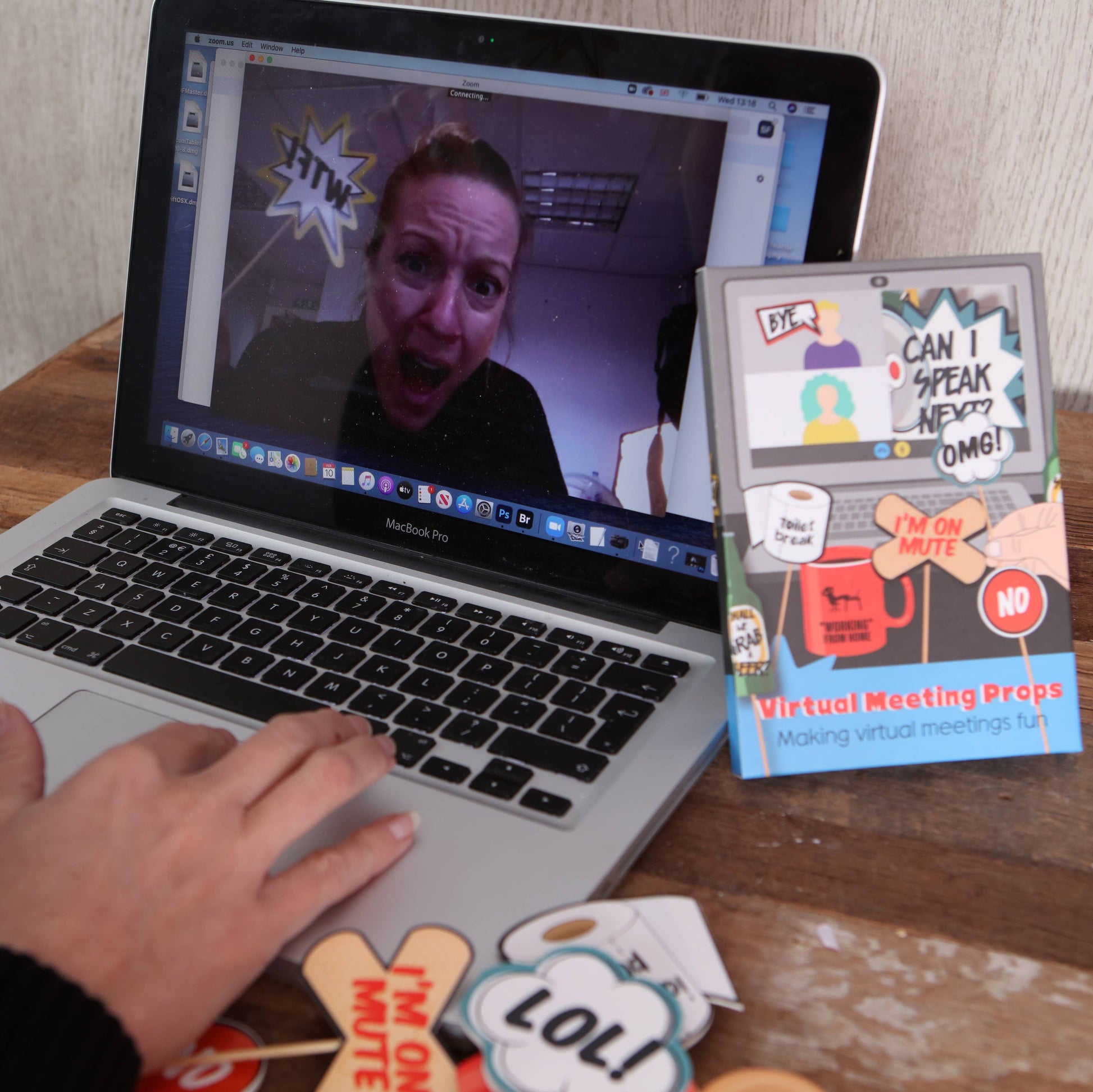 Mellow Monkey virtual meeting props featuring humorous handheld signs for Zoom calls on a desk with a laptop