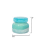 Mellow Monkey Volcano Artisan candle in a turquoise jar with a textured sea glass finish and blue lid. Sugared citrus and tropical fruit scent.
