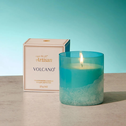 Mellow Monkey Volcano Artisan candle in a turquoise sea glass finish jar with a lit wick. Boxed with cliff-inspired design.