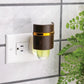 Mellow Monkey Walnut WallScents fragrance warmer plugged into a wall outlet with a gold accent band