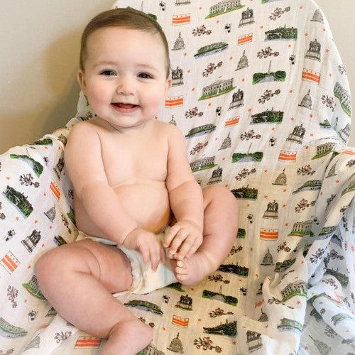 Mellow Monkey Washington DC print muslin swaddle blanket with a smiling baby sitting on it